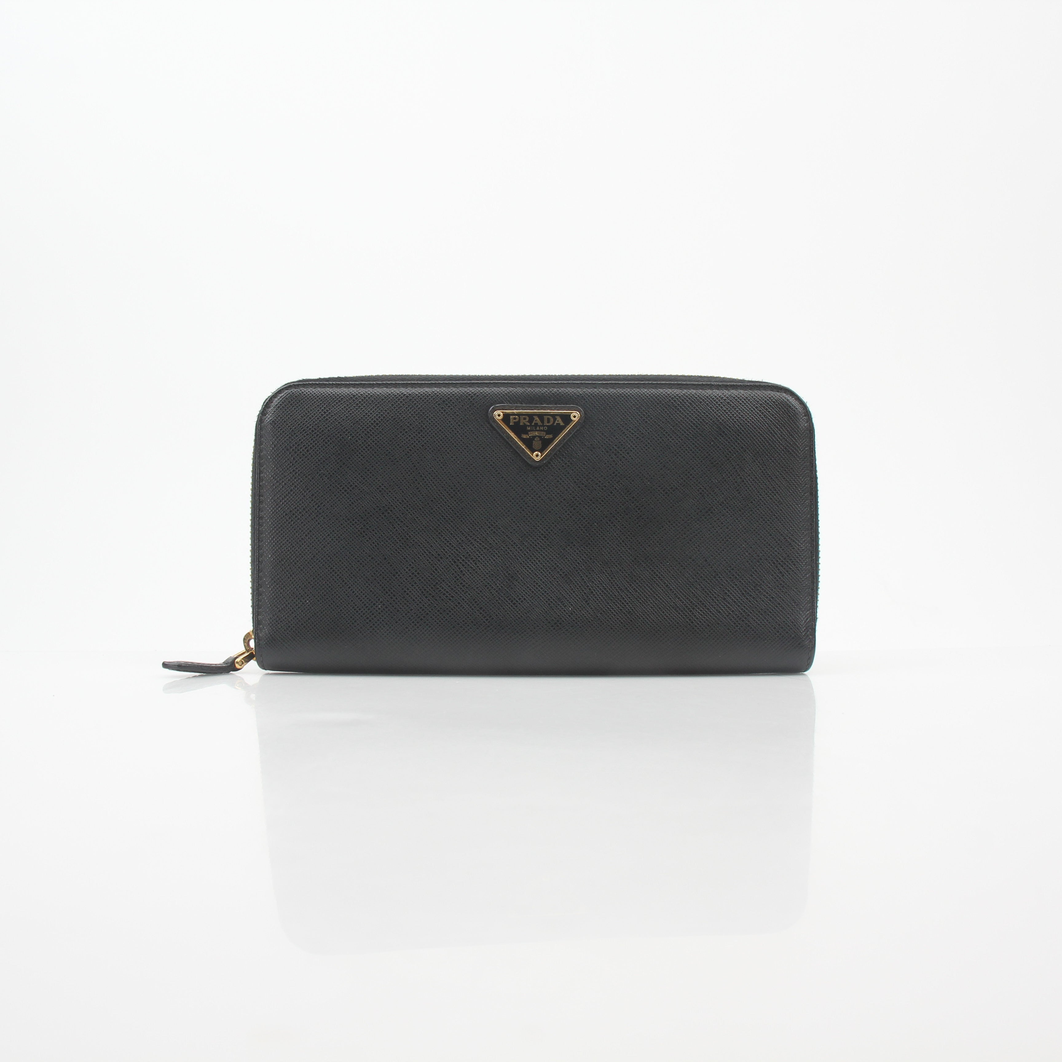 Prada black saffiano leather triangle zip-around wallet with gold-tone hardware, featuring a compact and stylish design.