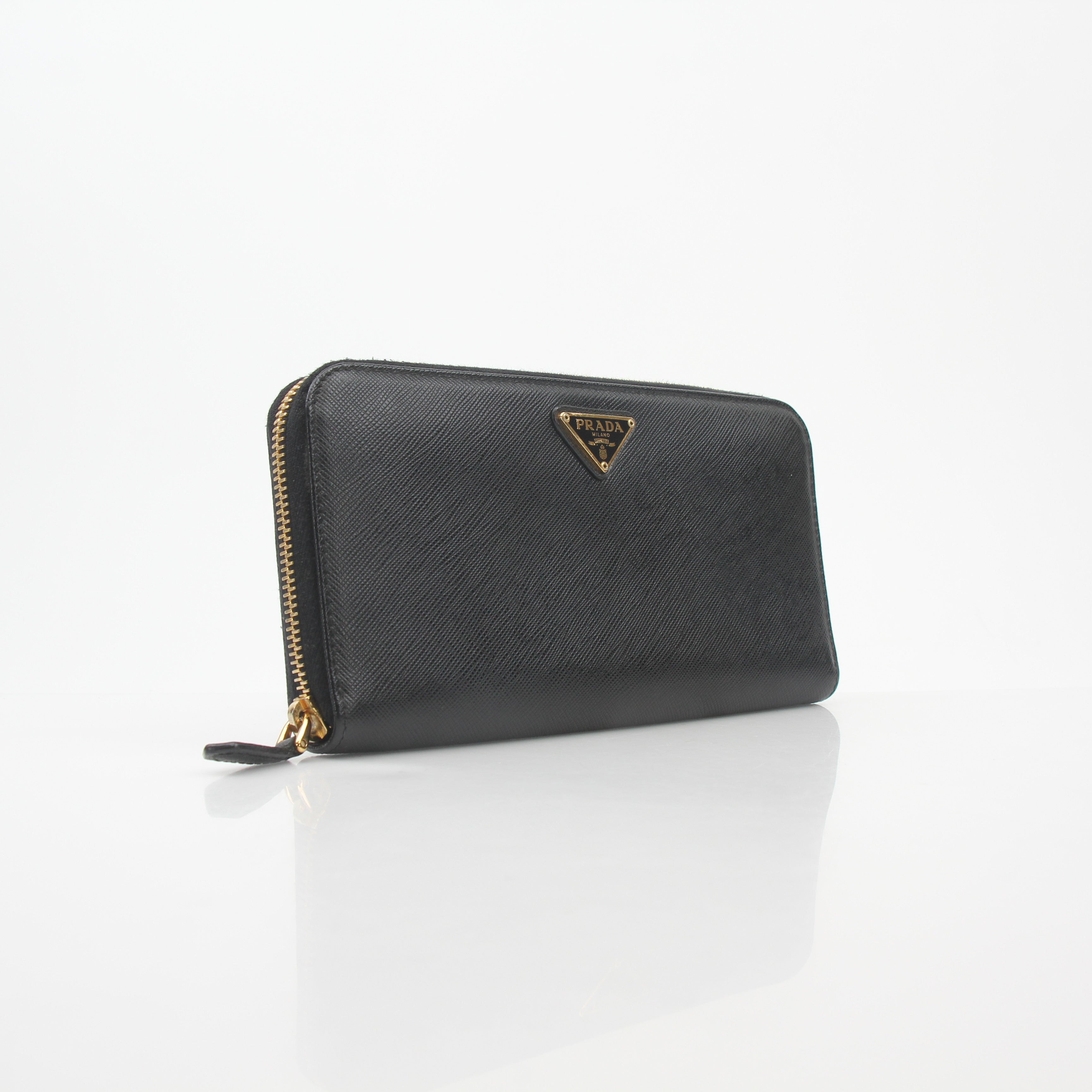 Black Prada Saffiano leather triangle zip-around wallet with gold accents, featuring a compact, structured design.