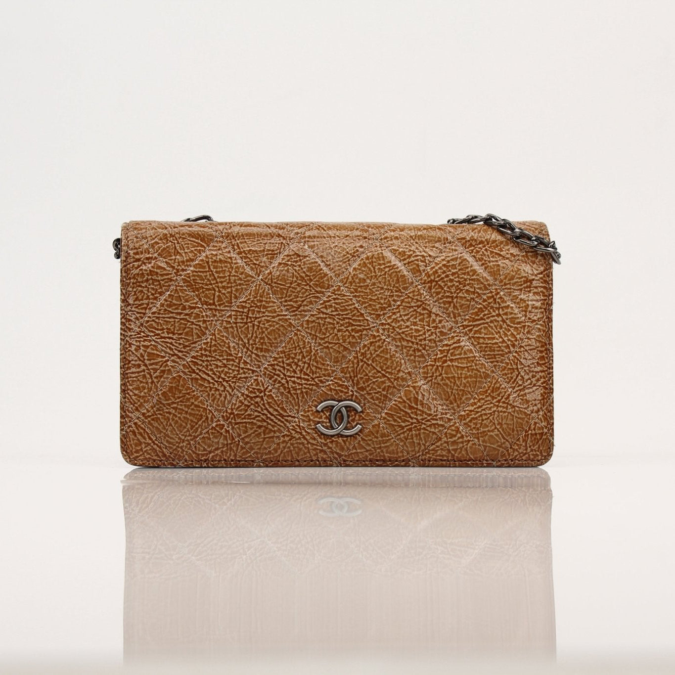 Chanel crinkled patent wallet on chain in gold, featuring compact design with gold chain strap and sleek patent finish.