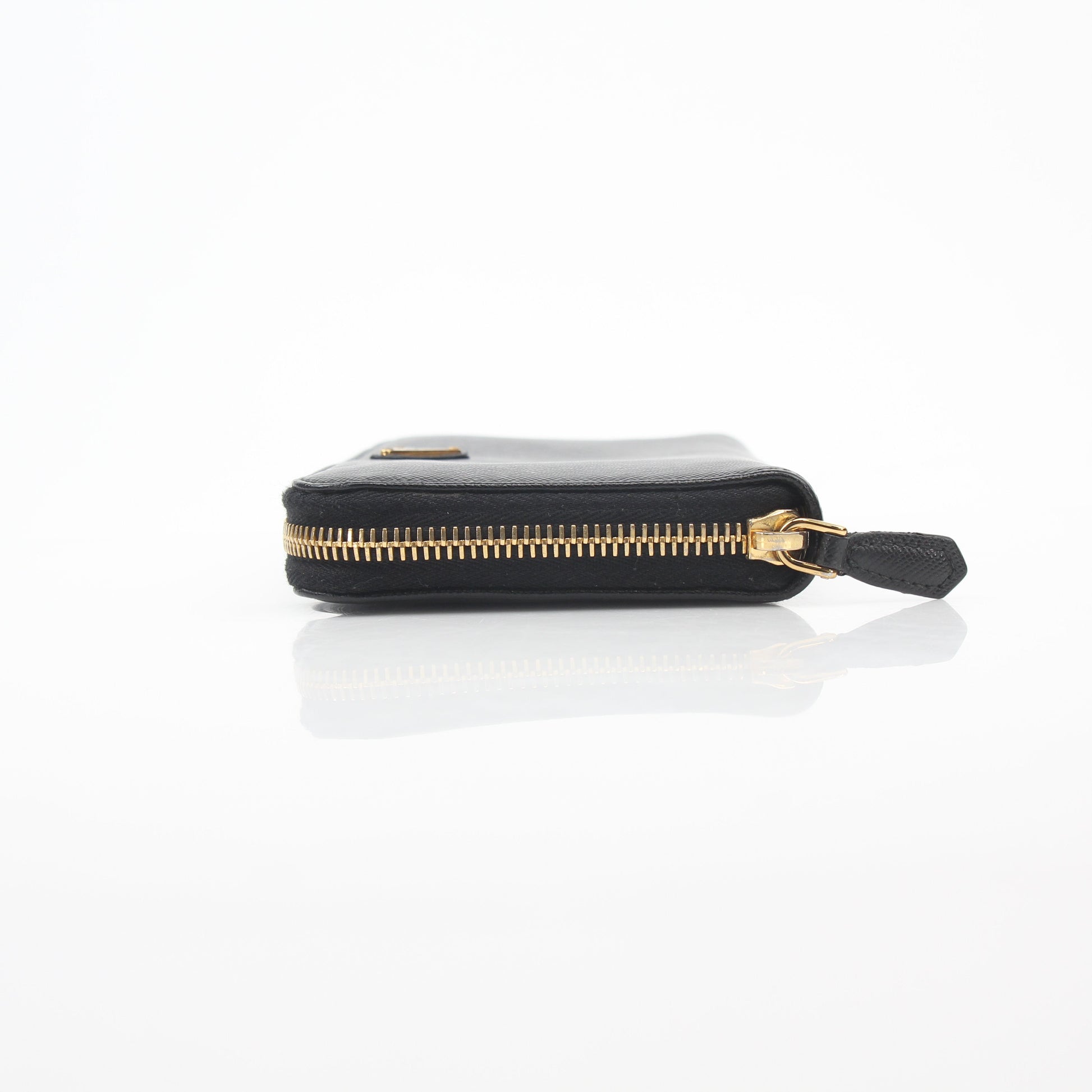 Prada black saffiano leather triangle zip-around wallet with gold accents, featuring compact design and multiple card slots.