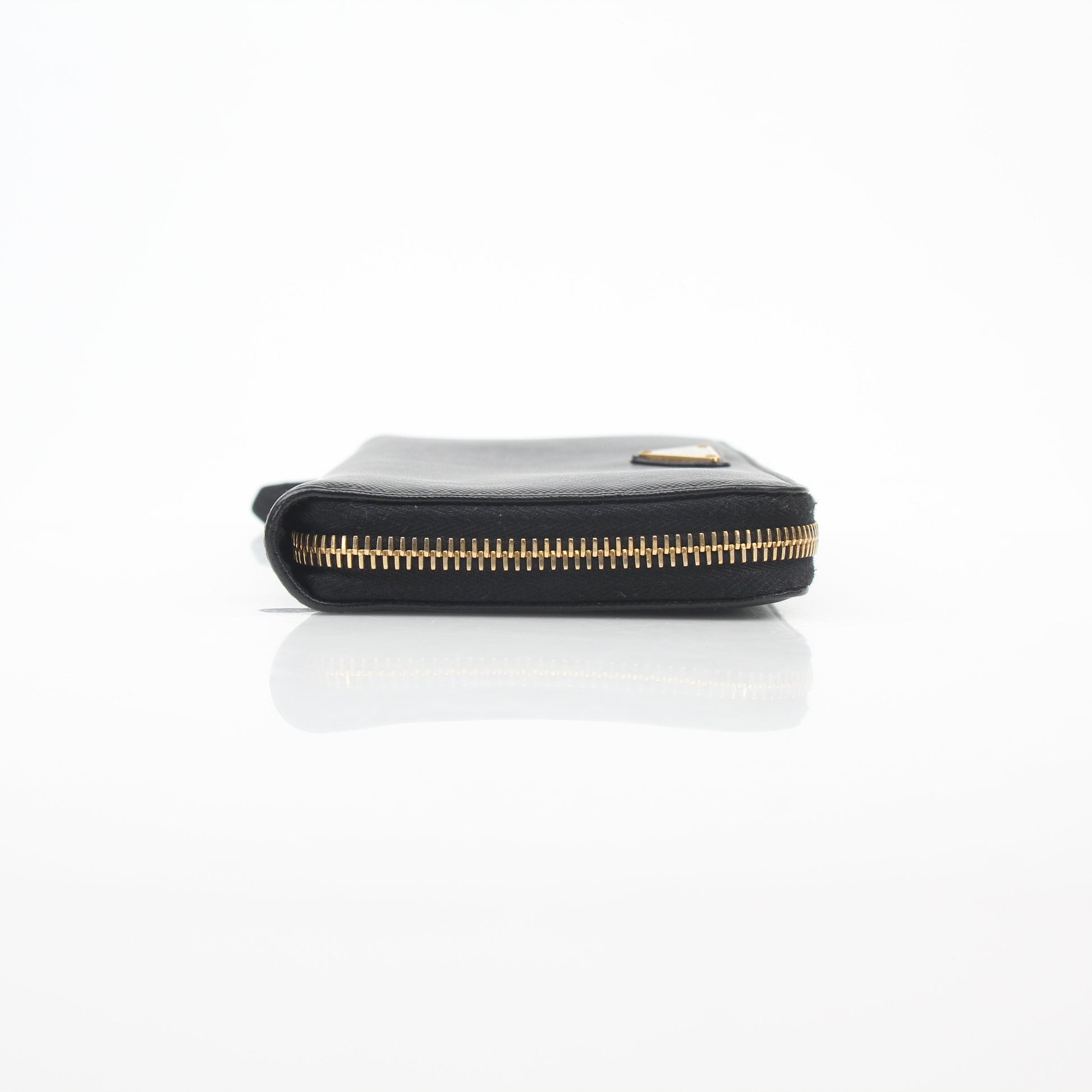 Prada black saffiano leather triangle zip-around wallet with gold hardware and compact design.