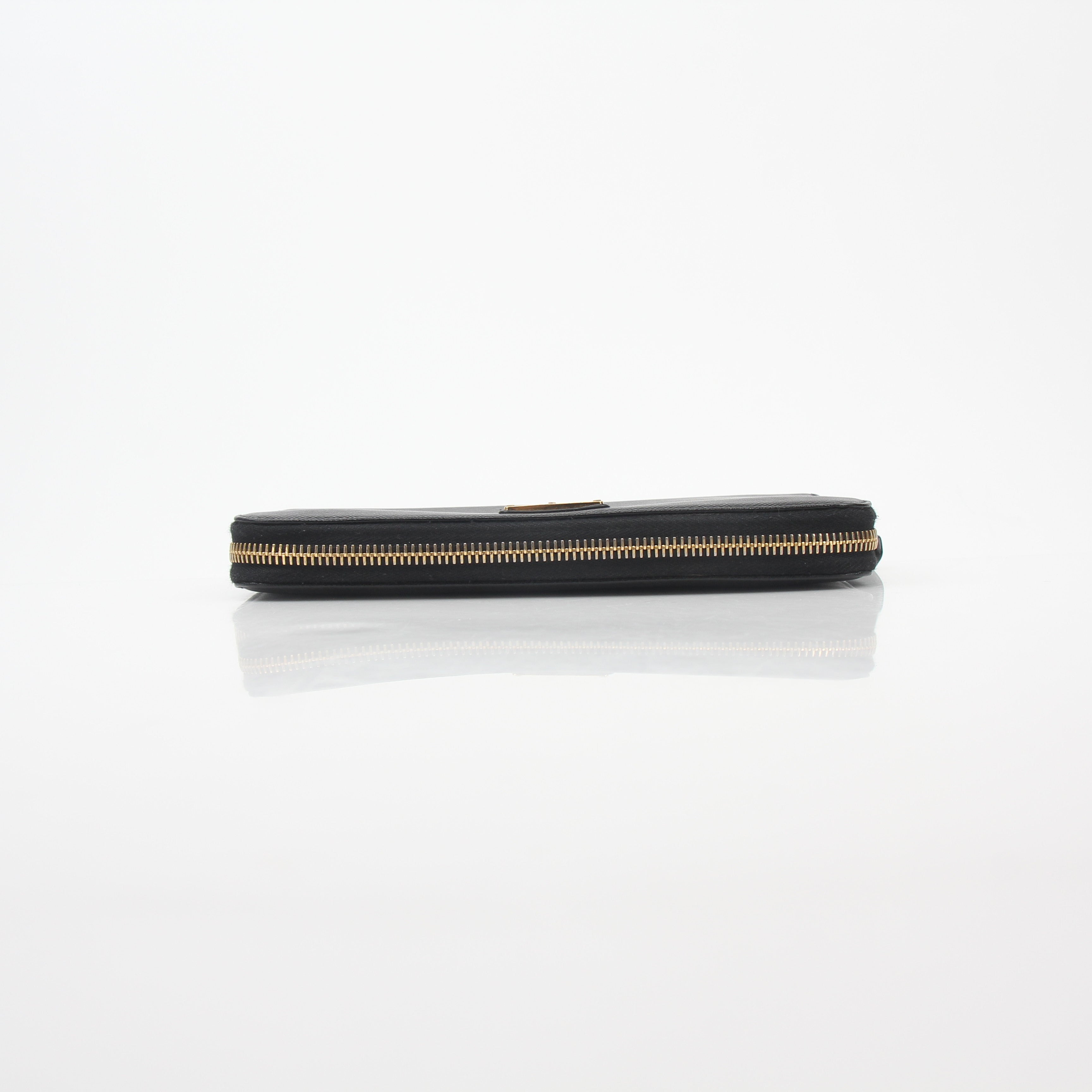 Prada black saffiano leather triangle zip-around wallet with gold-tone hardware and compact design.