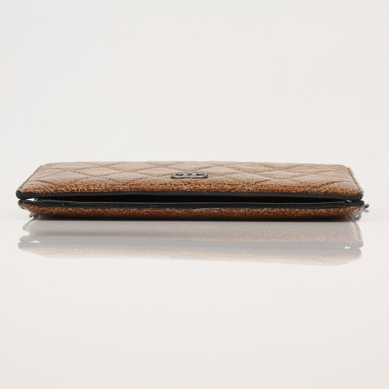 Chanel crinkled patent wallet on chain in gold, featuring a compact design with a sleek chain strap and signature logo detail.