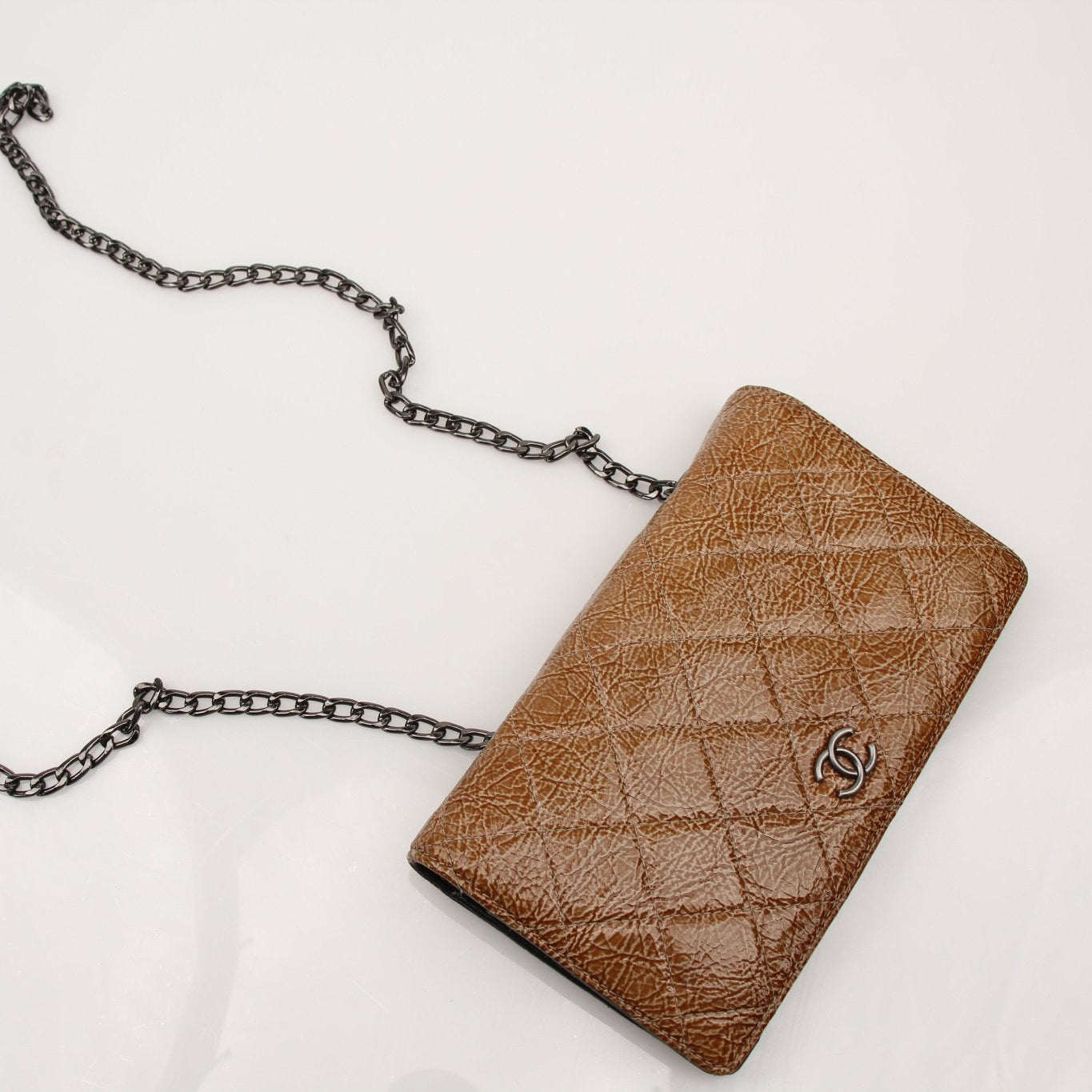 Chanel Crinkled Patent Wallet on Chain in gold with textured finish, compact design, and chain strap for versatile carrying.