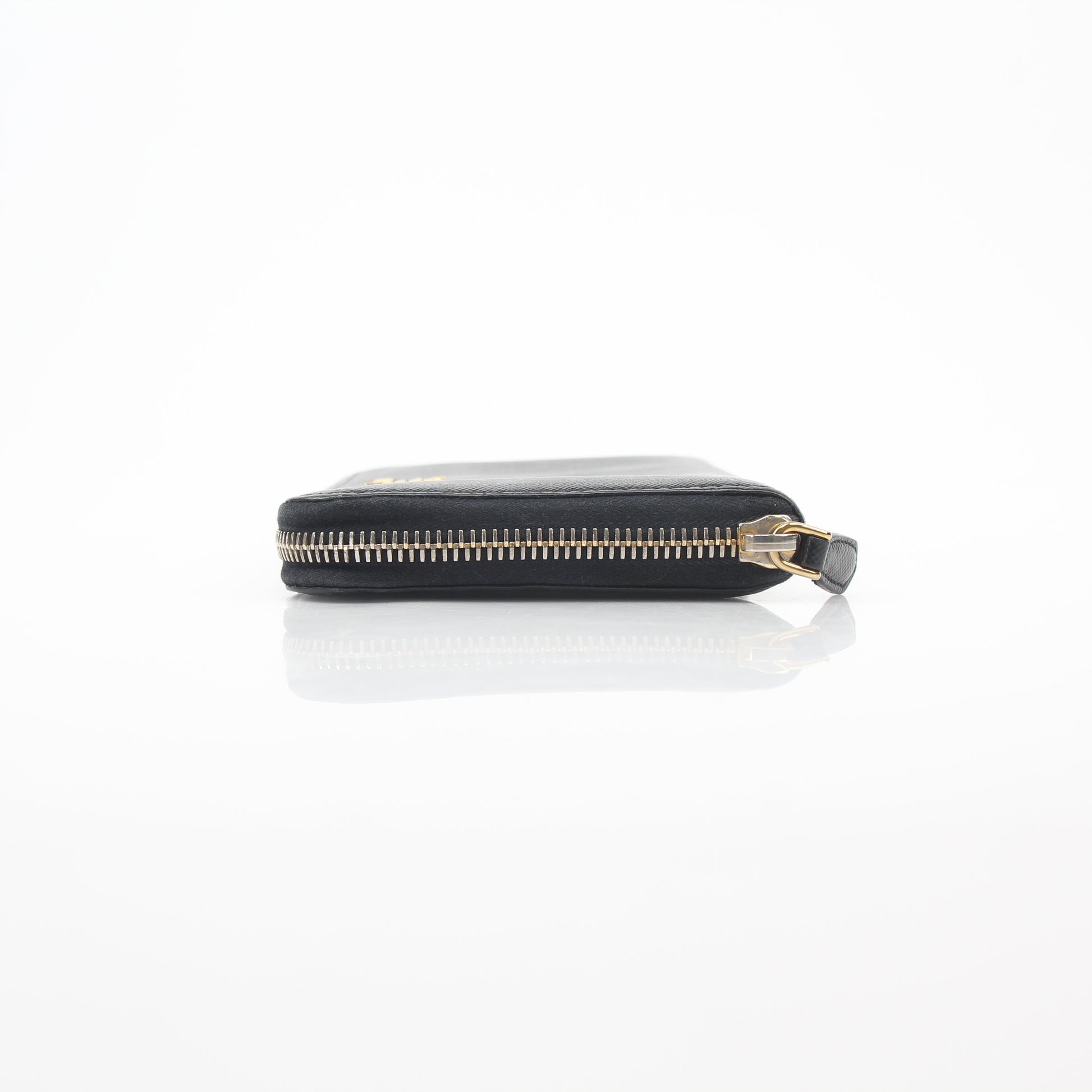 Prada black saffiano leather zip-around wallet with metal logo detail, featuring multiple card slots and a sleek design.