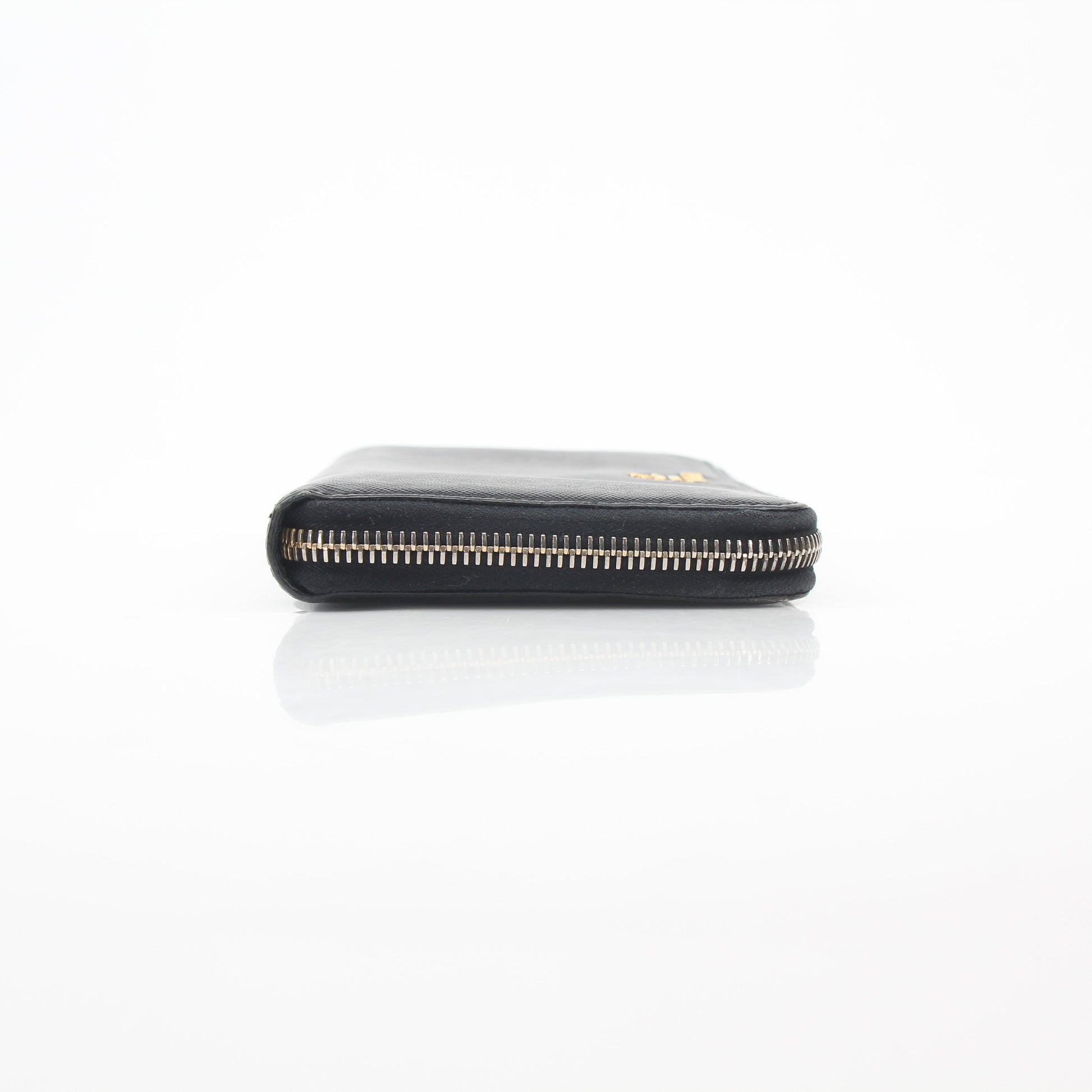 Prada black saffiano leather zip-around wallet with metal logo, featuring a sleek design and multiple card slots.