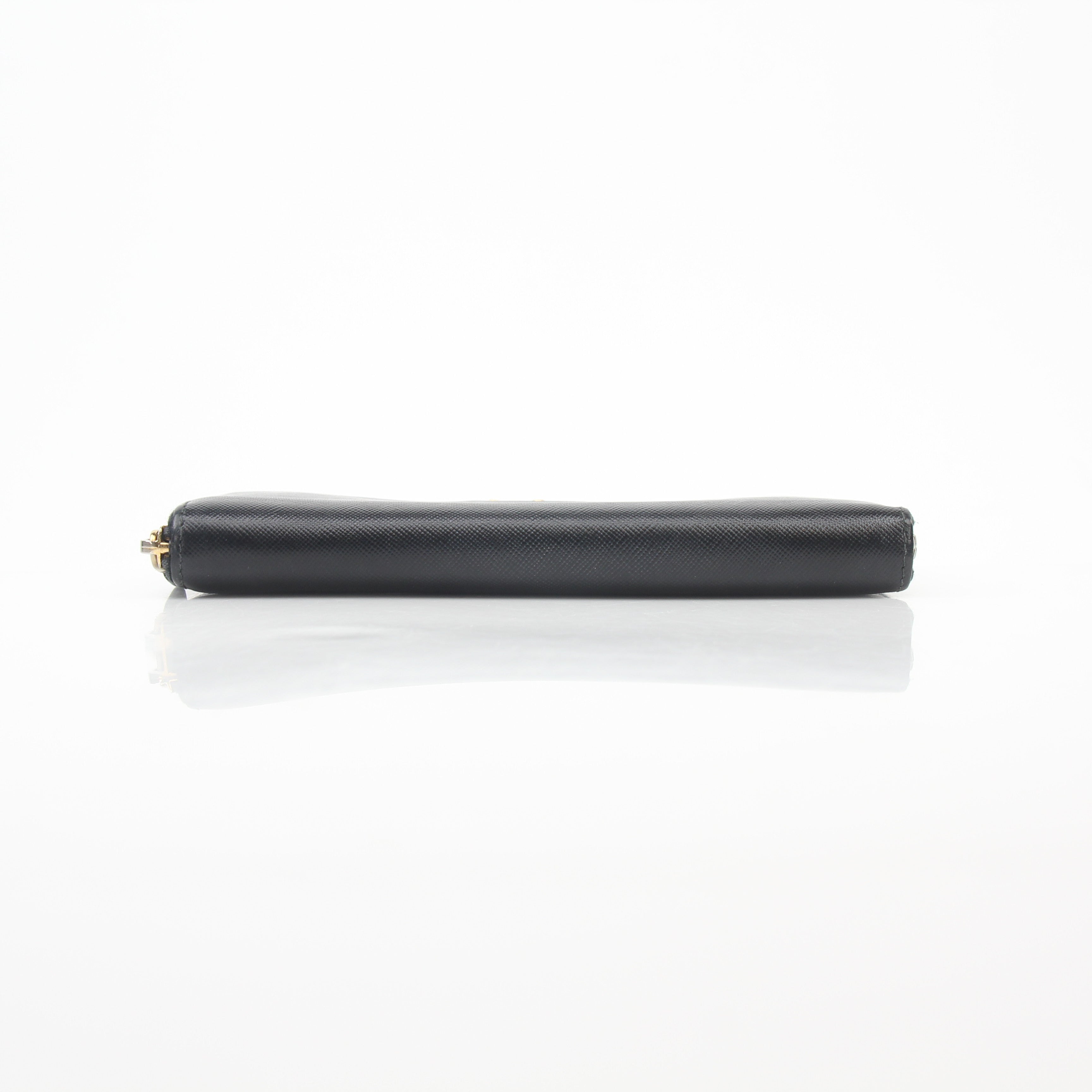 Prada black saffiano leather zip-around wallet with metal logo, featuring gold hardware and multiple card slots.