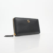 Gucci black GG Marmont zip-around wallet with gold hardware and quilted chevron pattern, featuring a zip closure and brand logo.