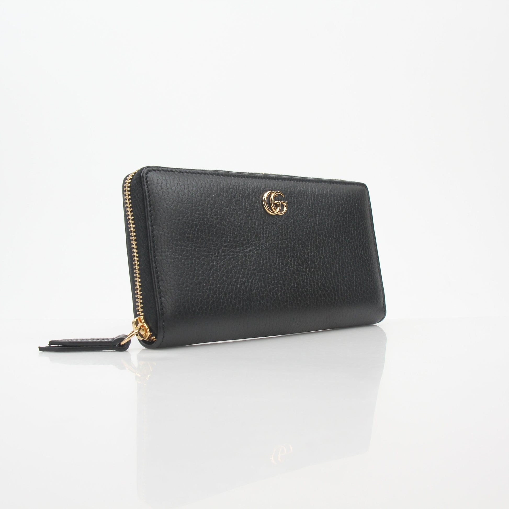 Gucci black GG Marmont zip-around wallet with gold hardware and quilted chevron pattern, featuring a zip closure and brand logo.