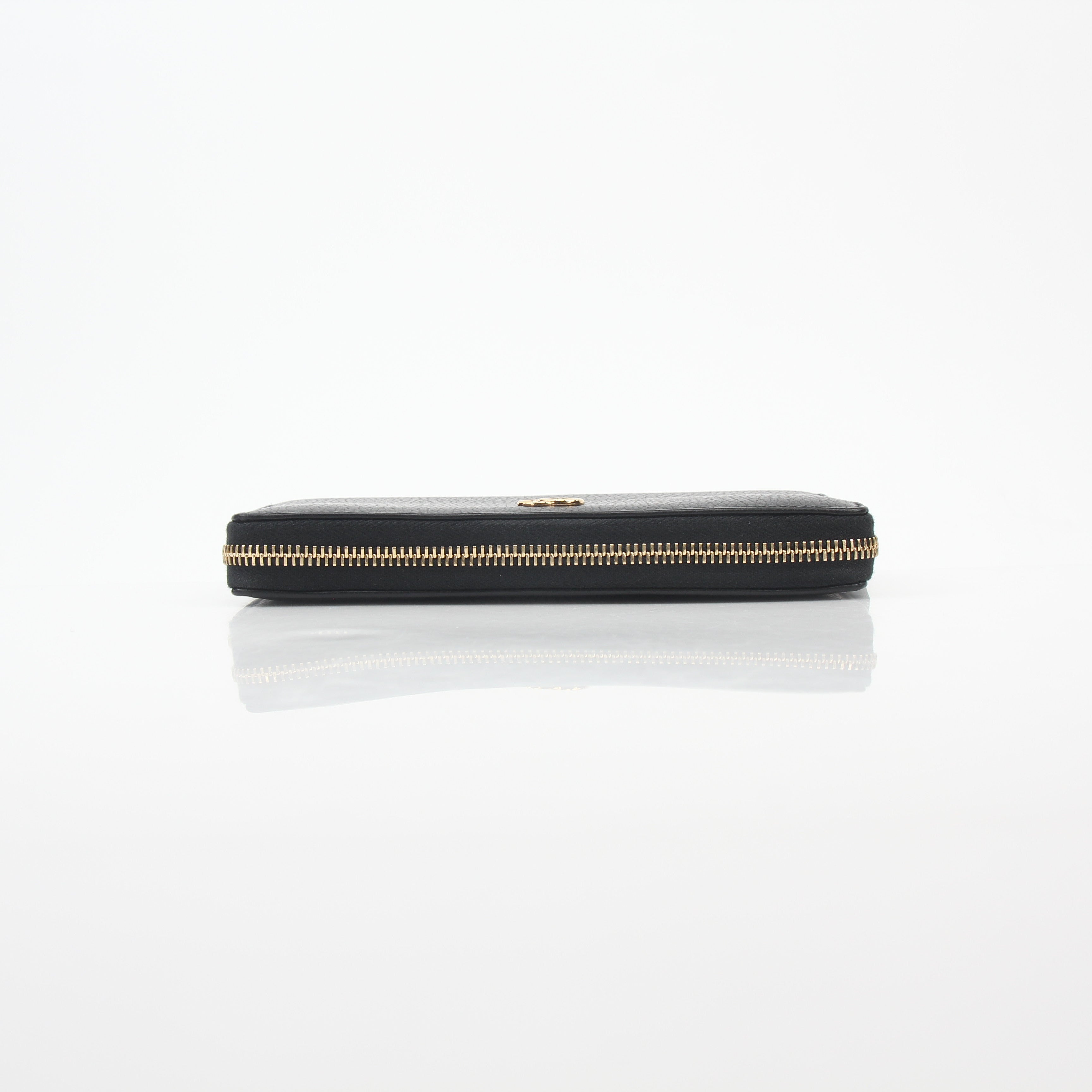 Gucci black GG Marmont zip-around wallet with gold hardware, featuring quilted leather and a compact, stylish design.
