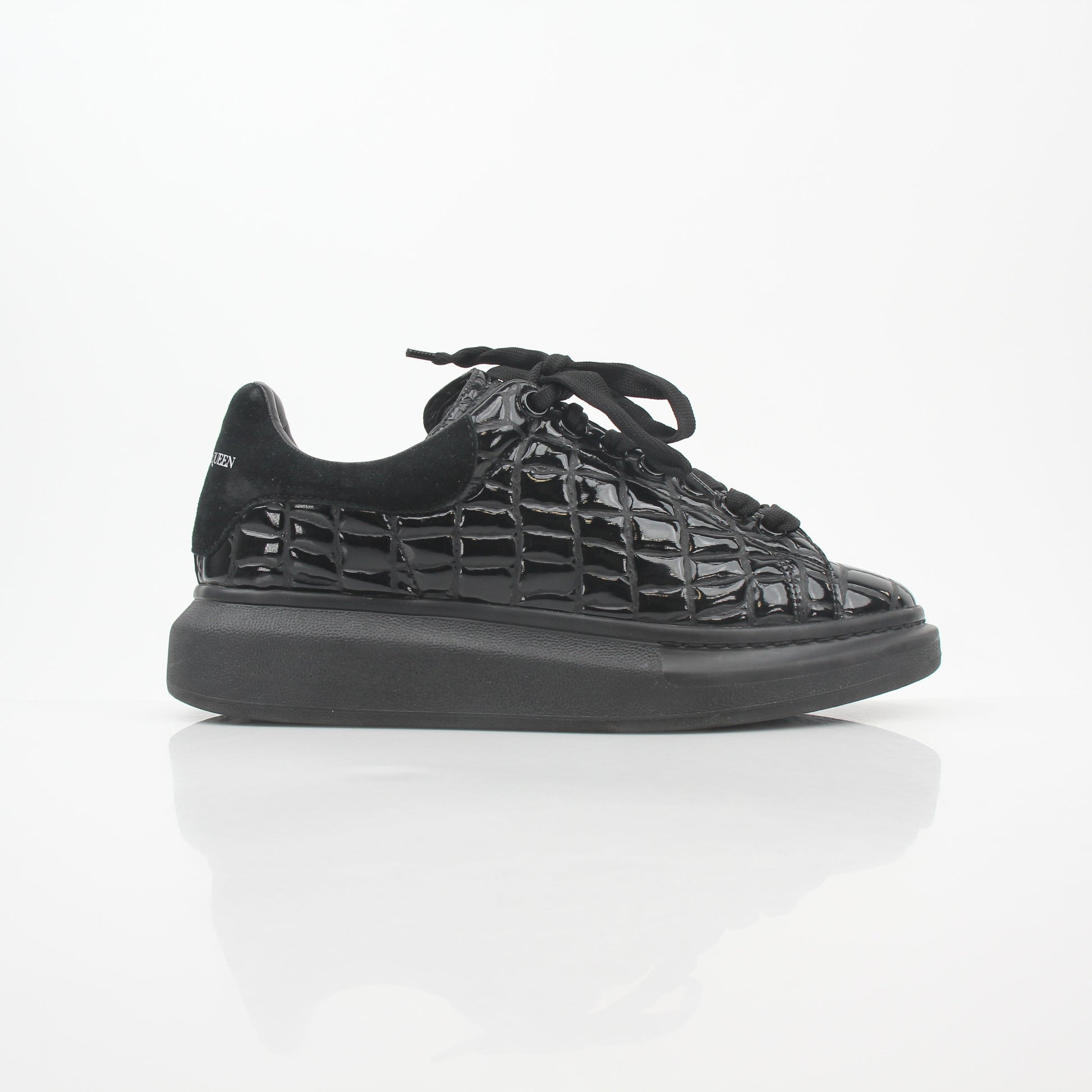 Black croc-embossed Alexander McQueen oversized sneakers with chunky design and white rubber soles.