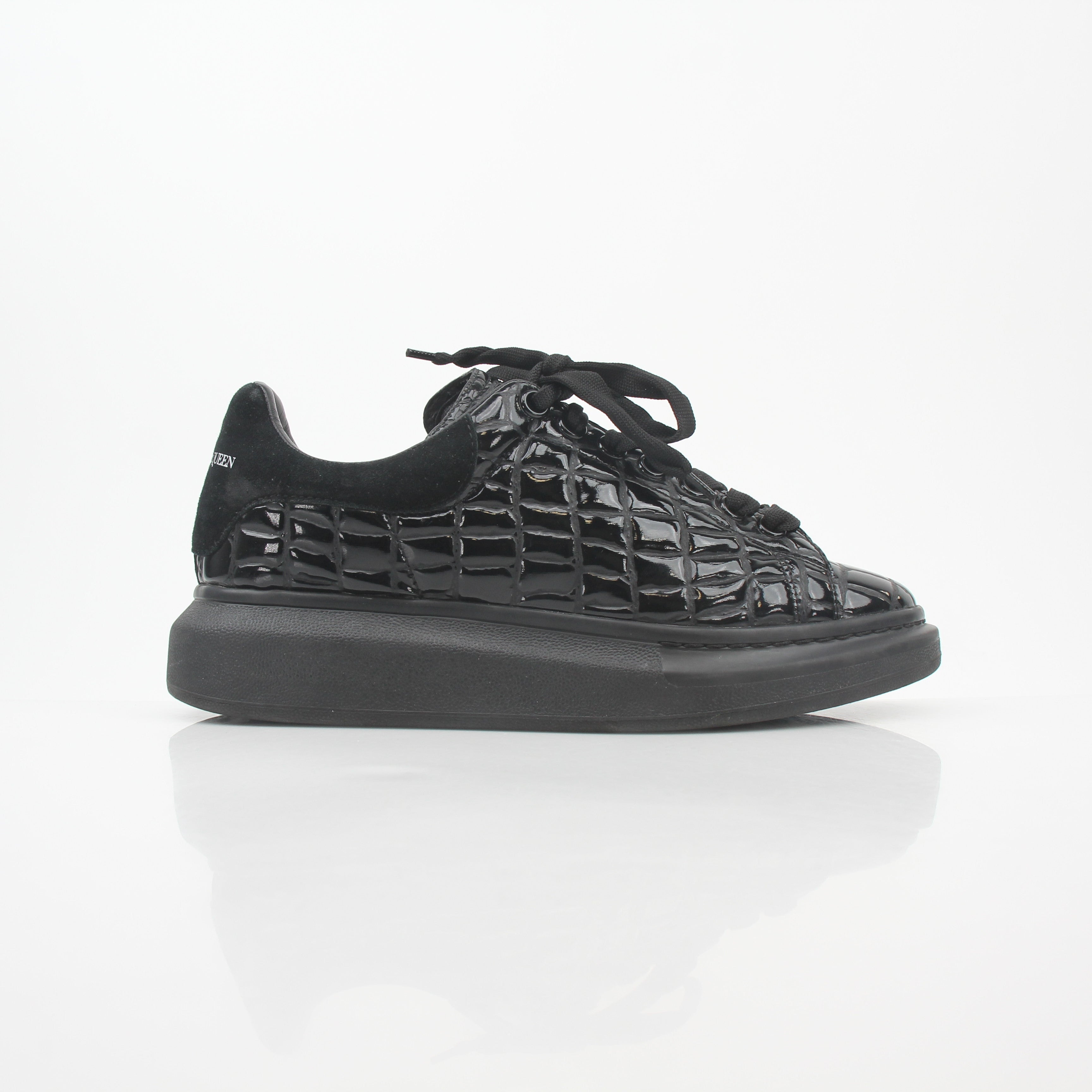 Black croc-embossed Alexander McQueen oversized sneakers with chunky design and white rubber soles.
